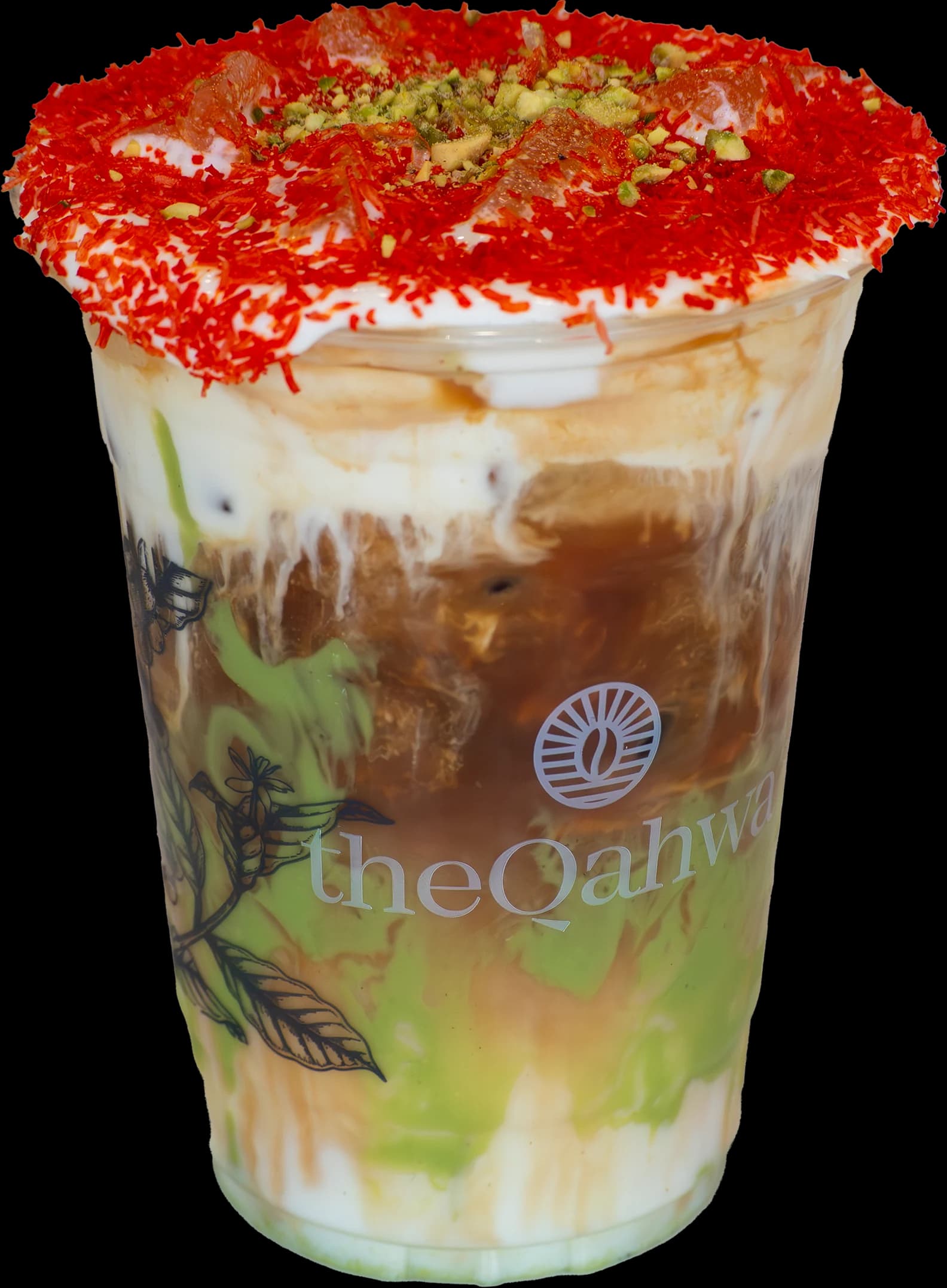 Iced Knafeh Latte in a clear theQahwa cup — pistachio cream and espresso layered under a soft milk top, rimmed with red-dusted toasted kataifi and crushed pistachio.