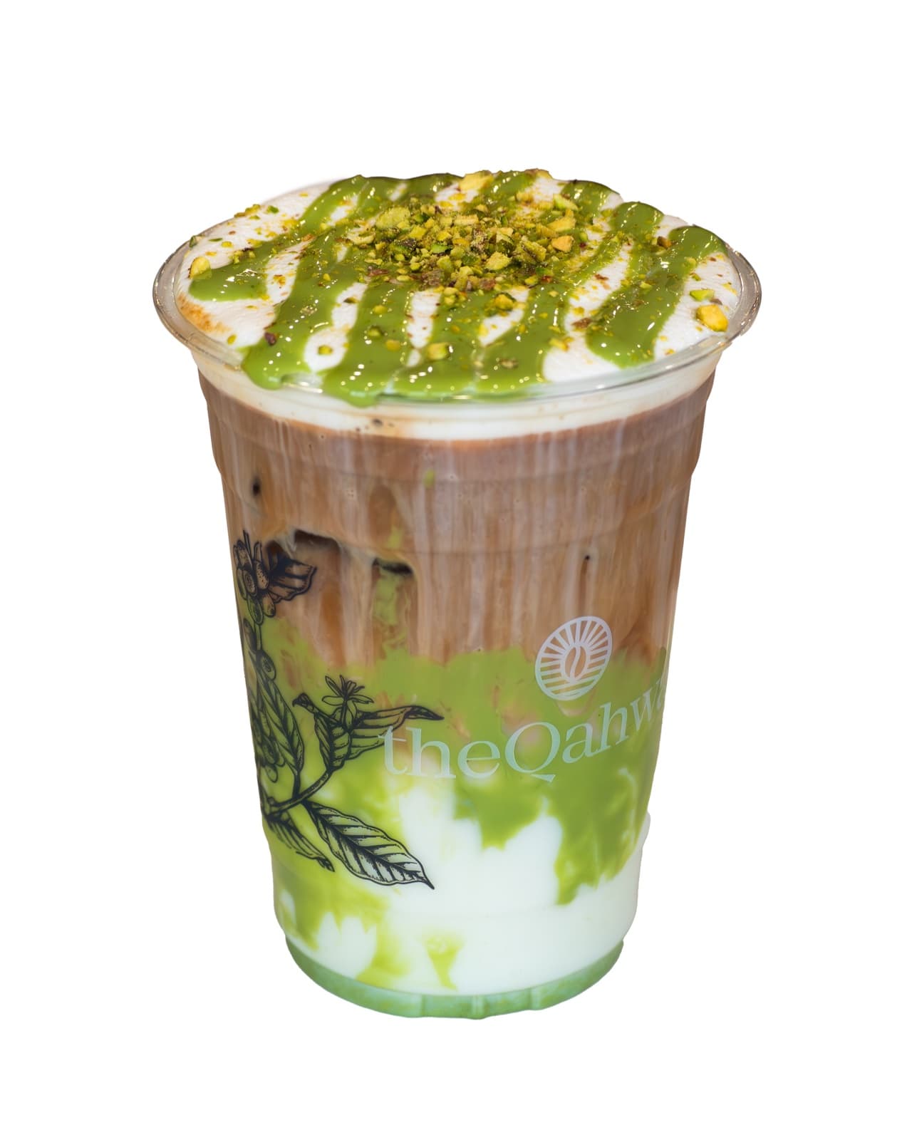 Iced Pistachio Latte in a clear theQahwa cup — espresso and milk layered over ice, finished with pistachio cream and crushed pistachio on top.