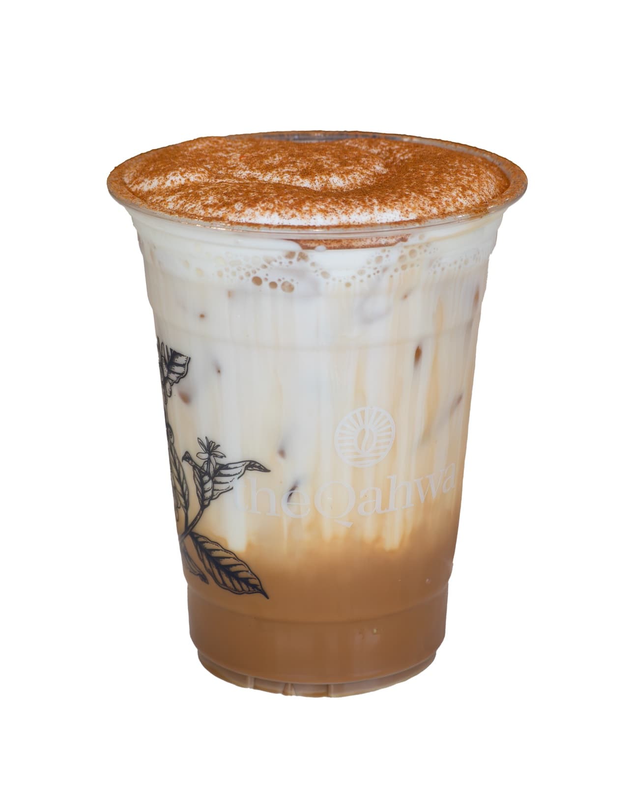 Iced Spanish Latte in a clear theQahwa cup — espresso and condensed milk over ice under a thick velvety foam dusted with cinnamon.